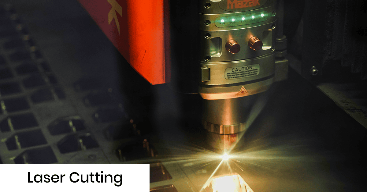 Mazak laser cutting machine cutting metal sheet with a bright beam and sparks in a dark workshop