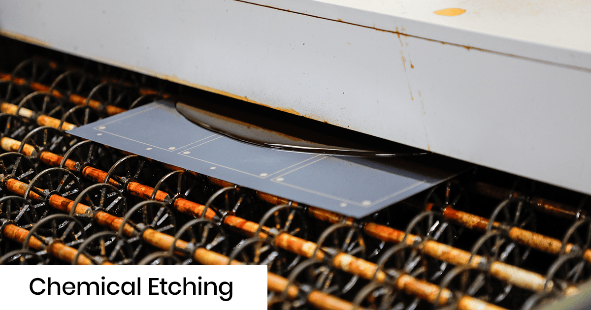 Industrial chemical etching process on a PCB sheet entering a machine; blue board with etched patterns visible as it advances through rollers.