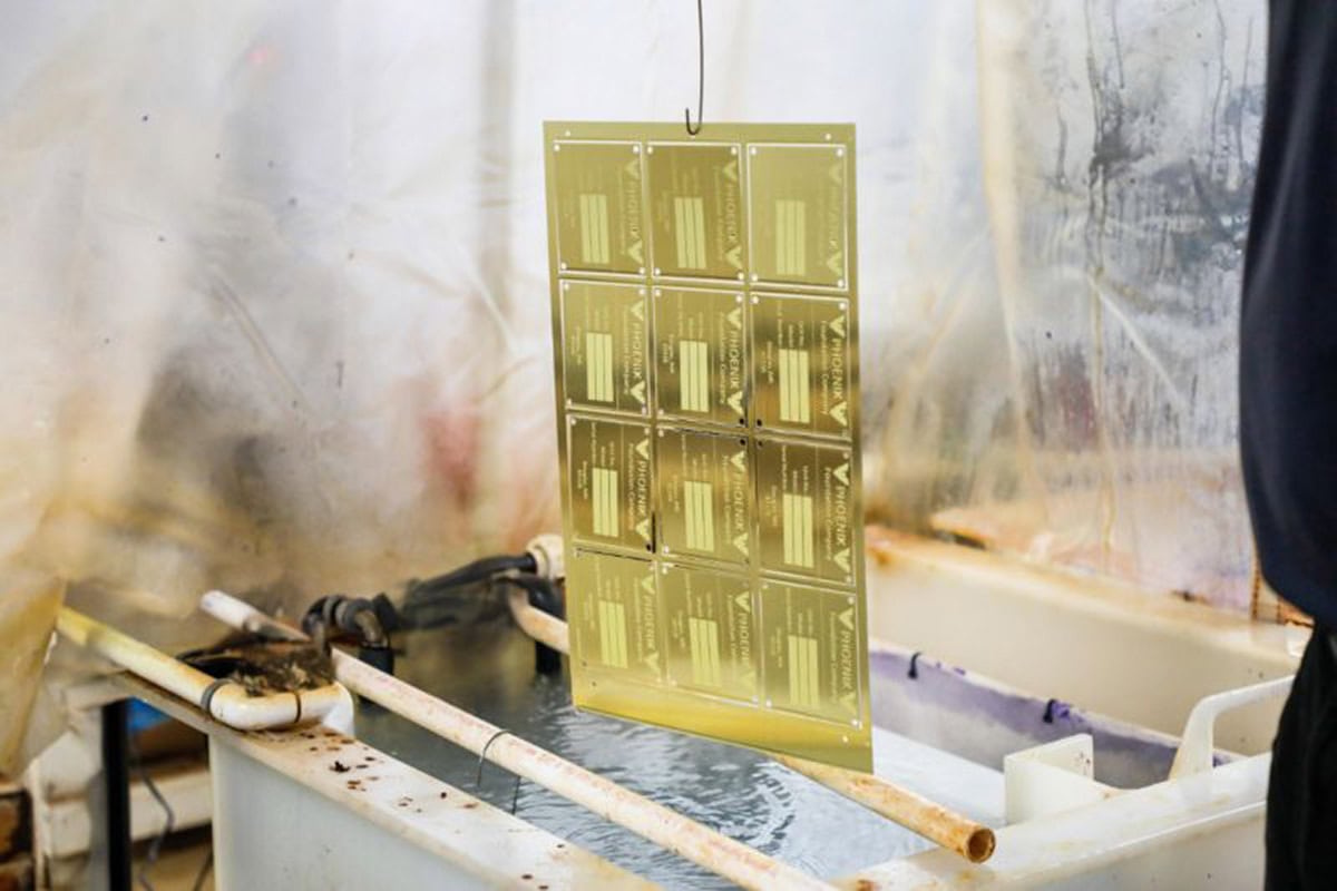 etched metal sheet being cleaned in chemical bath